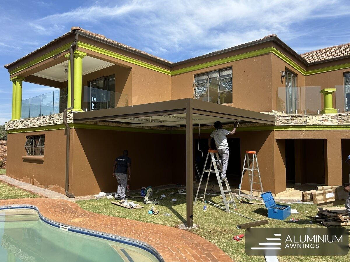 Bronze-framed louvre roof with white blades over the Hermanus patio, blades closed.