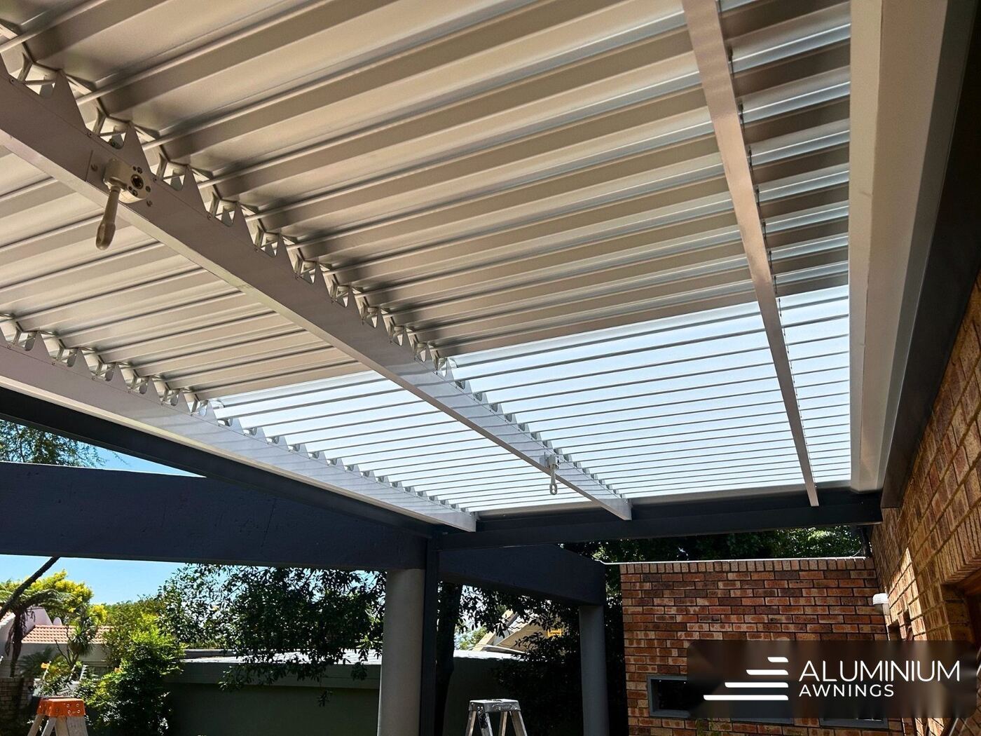 Manual louvre awning in charcoal frame with white louvre blades — Sandown, Blouberg