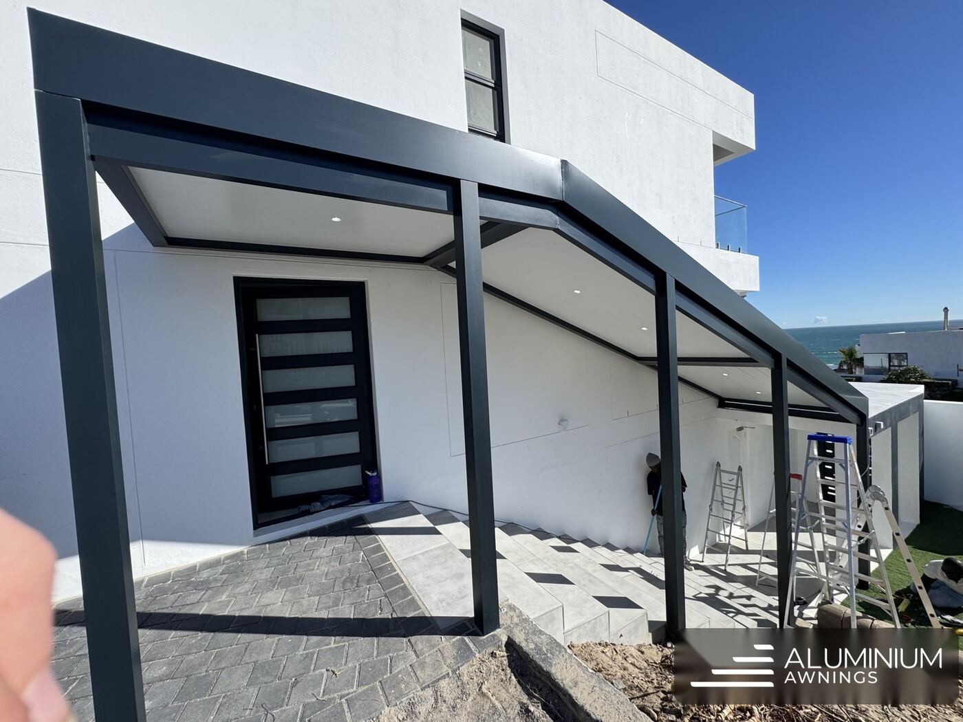 Enclosed aluminium patio with a charcoal-framed white ceiling in Blouberg, Cape Town