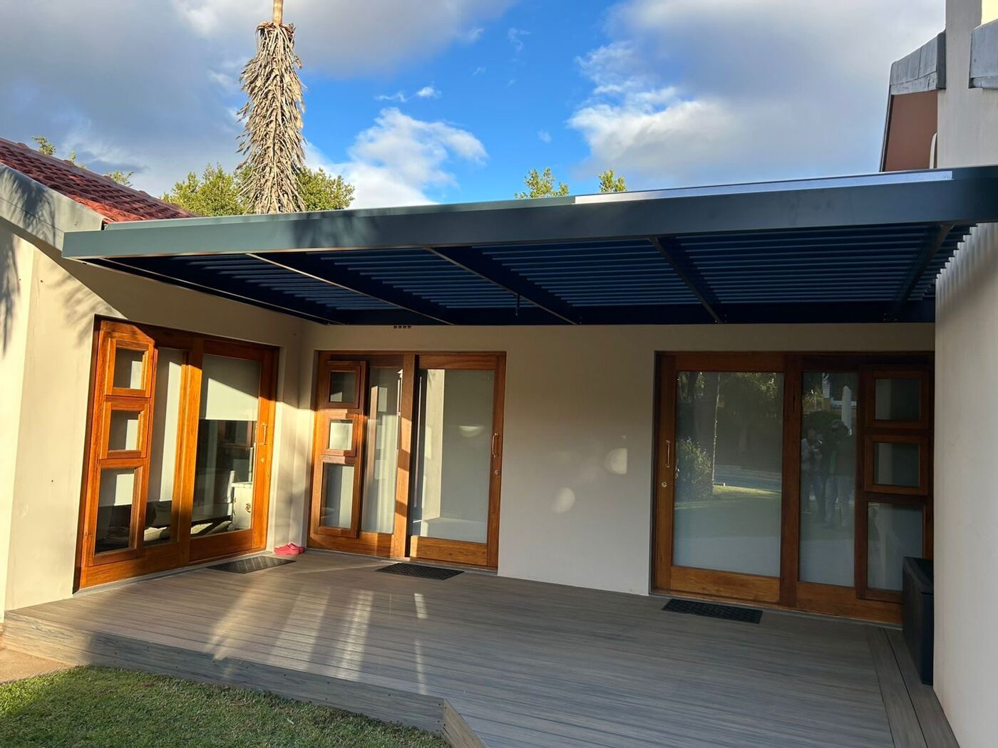 Charcoal frame & blades aluminium louvre awning over a patio in Durbanville, Cape Town.