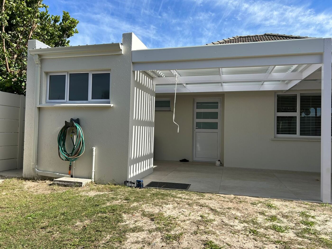 White louvre awning over the paved patio in Bellville, blades open.