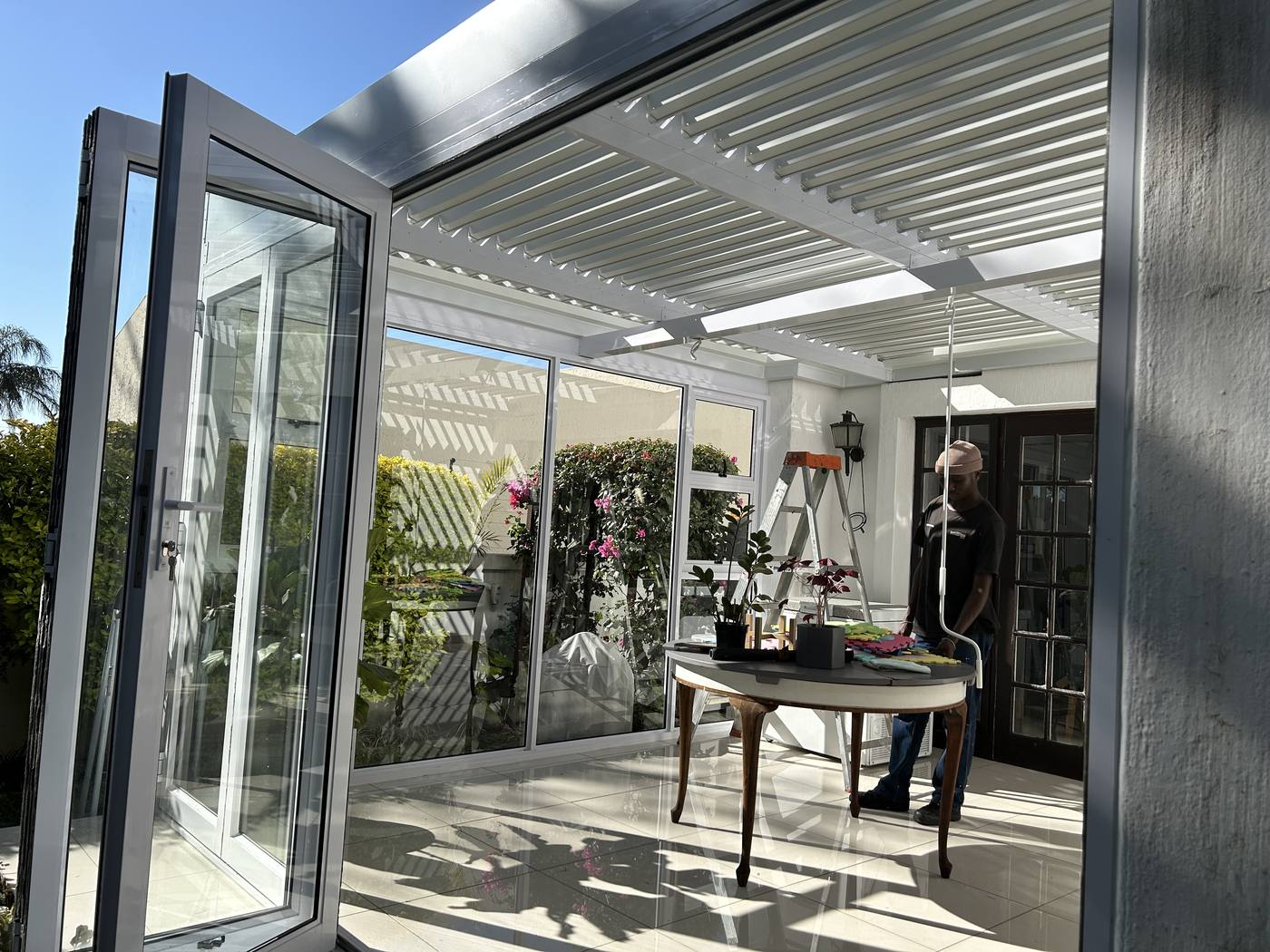 Glass bi-fold doors folded open at a Constantia patio enclosure