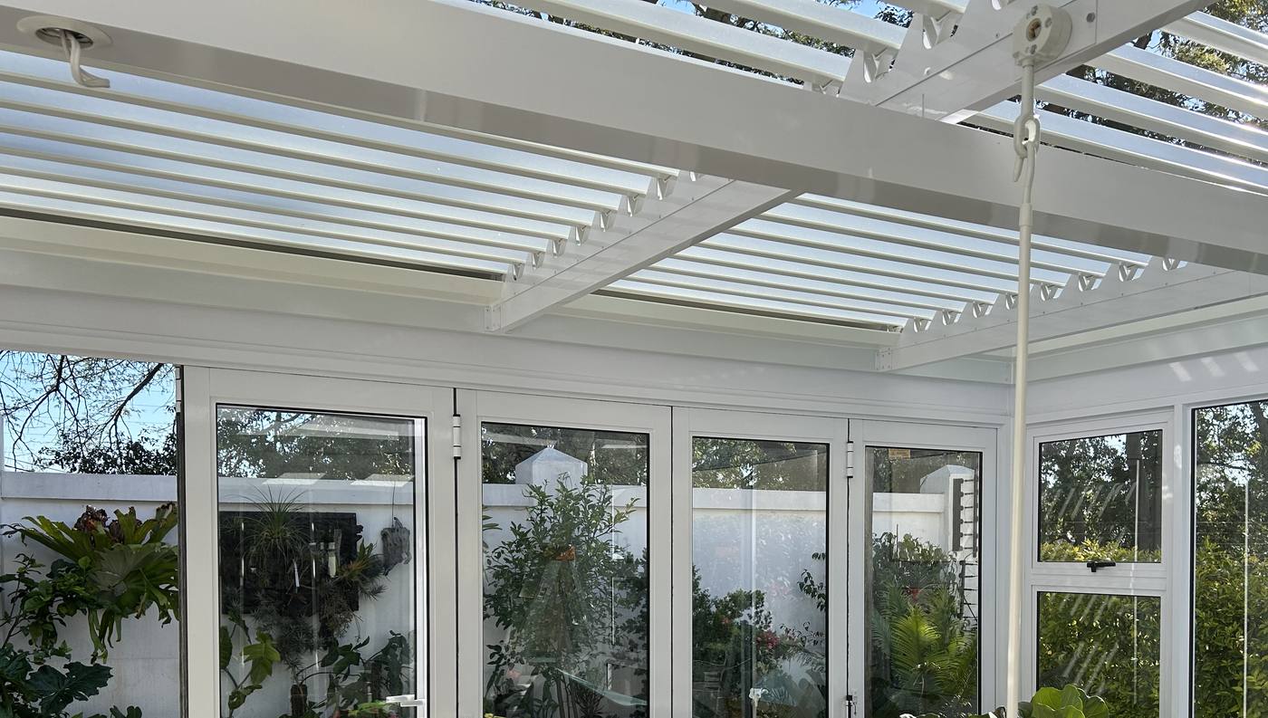White louvre roof over a glazed patio enclosure