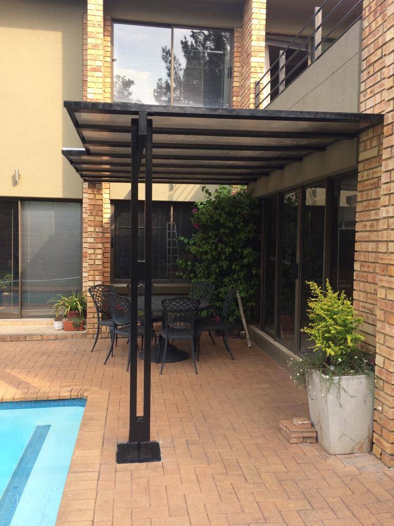 Clear polycarbonate walkway awning on a black frame