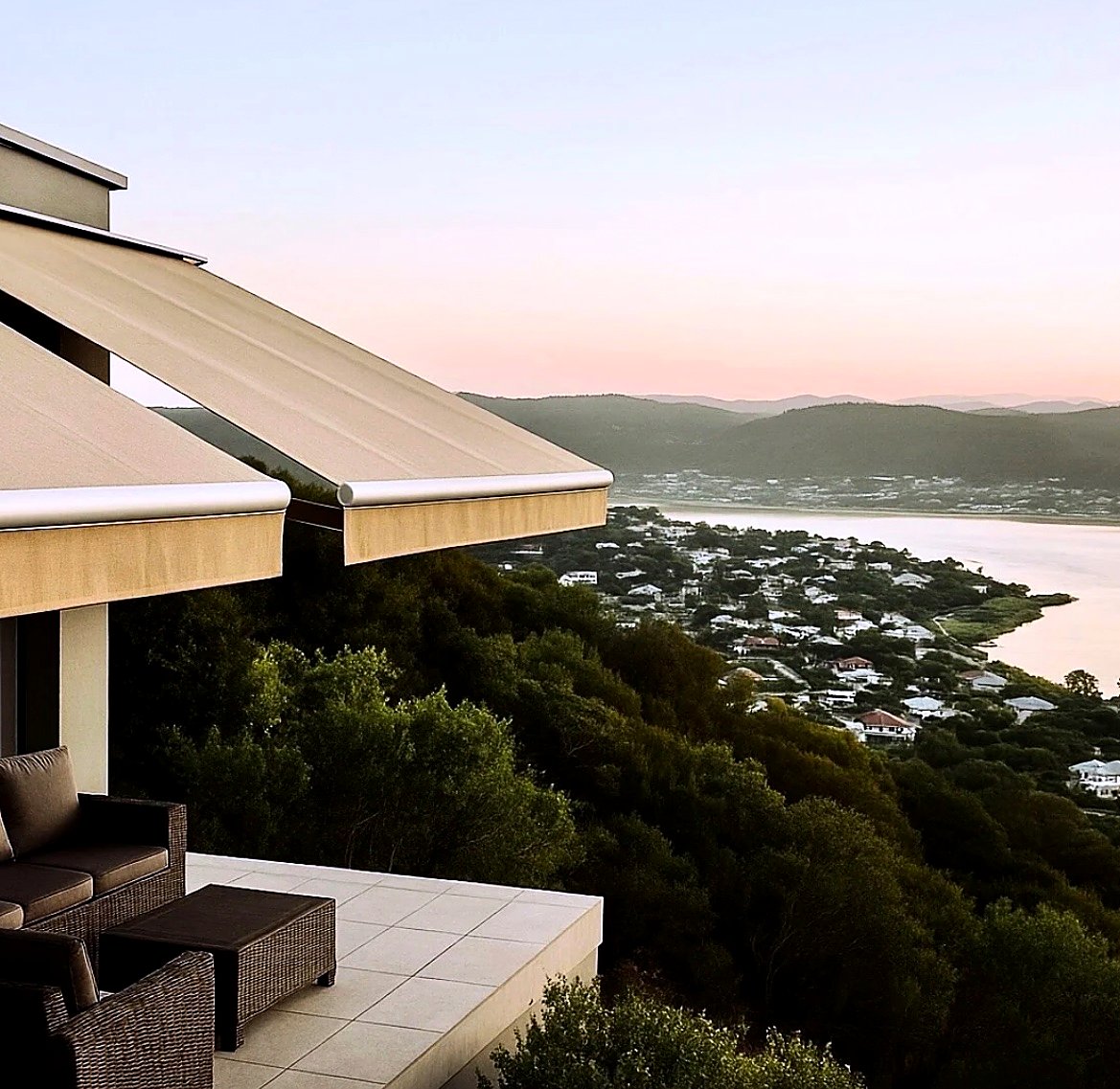 Retractable folding-arm awnings over a lagoon-view balcony